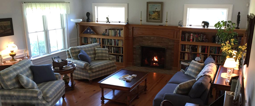 The living room includes spacious seating, fireplace, library, and board games