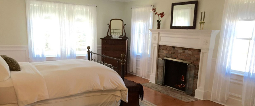 The Coffey House Suite includes a wrought iron bed, fireplace, and sitting area